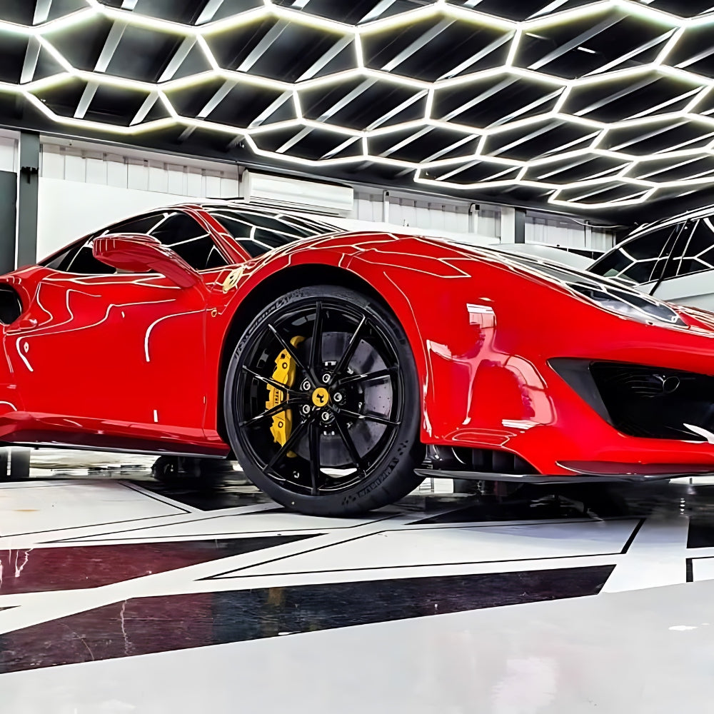 Red car parked under a ceiling with hexagon LED grid lights, creating a striking and modern visual effect