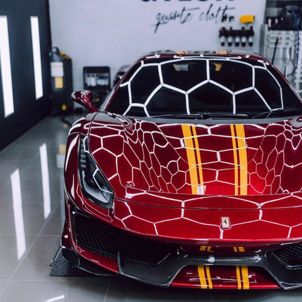 Red car situated above a grid of hexagon LED lights, creating a bold visual contrast and enhancing the car’s appearance