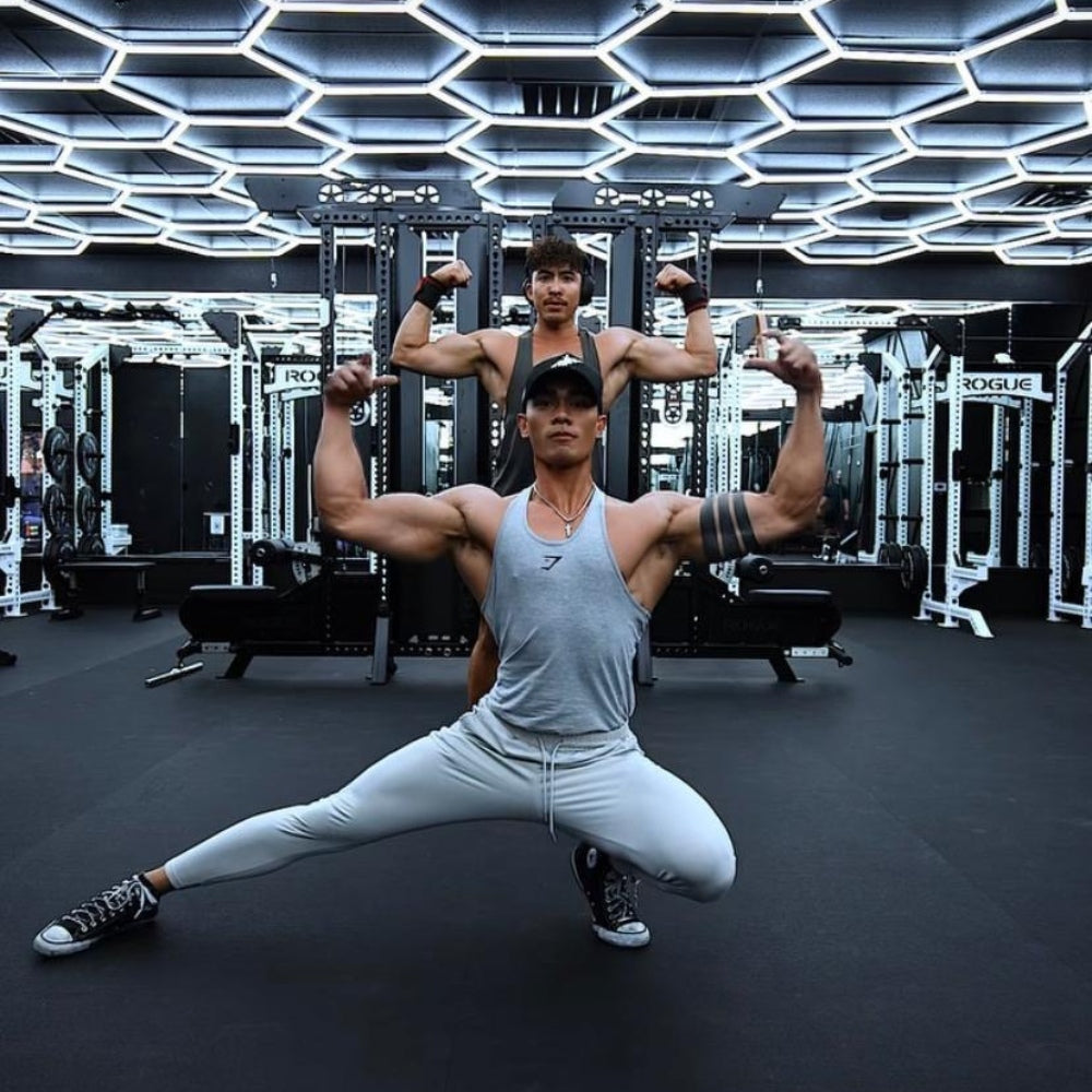 Men exercising in a gym with hexagon LED grid lights overhead, providing bright and modern illumination for their workout