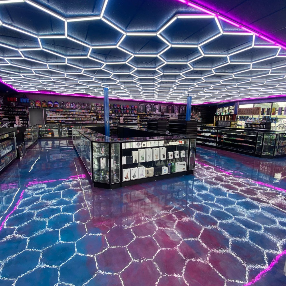 Ceiling featuring hexagon LED grid lights with a colorful border, casting dynamic shadows and creating a vibrant atmosphere on the floor